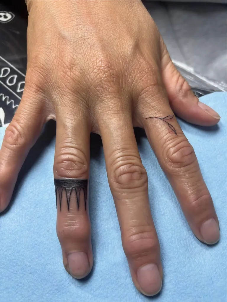 Ornamental black band tattoo on a finger by Melissa at Golden Child Tattoo in Escondido