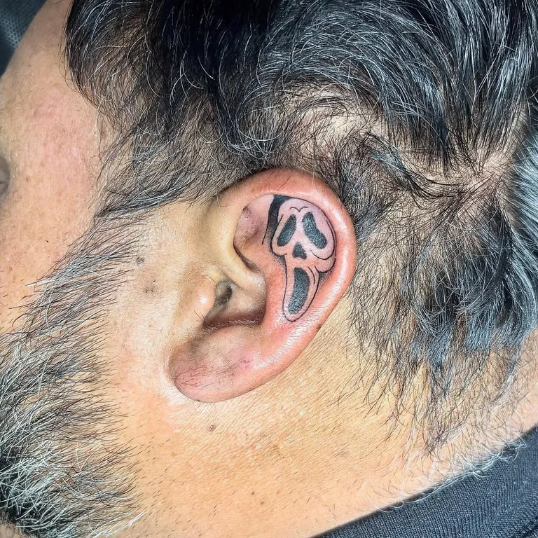 Ghost mask tattoo inside the ear by Melissa at Golden Child Tattoo in Escondido