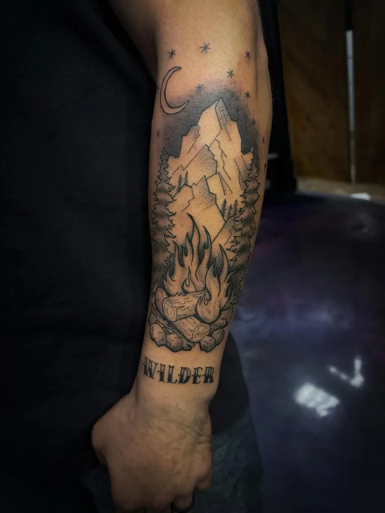 Mountain and bonfire forearm tattoo with lettering by Melissa at Golden Child Tattoo in Escondido