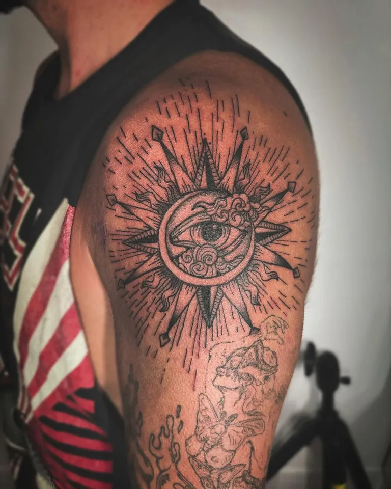 Sun with an eye, surrounded by rays, tattooed on the upper arm by Melissa at Golden Child Tattoo in Escondido