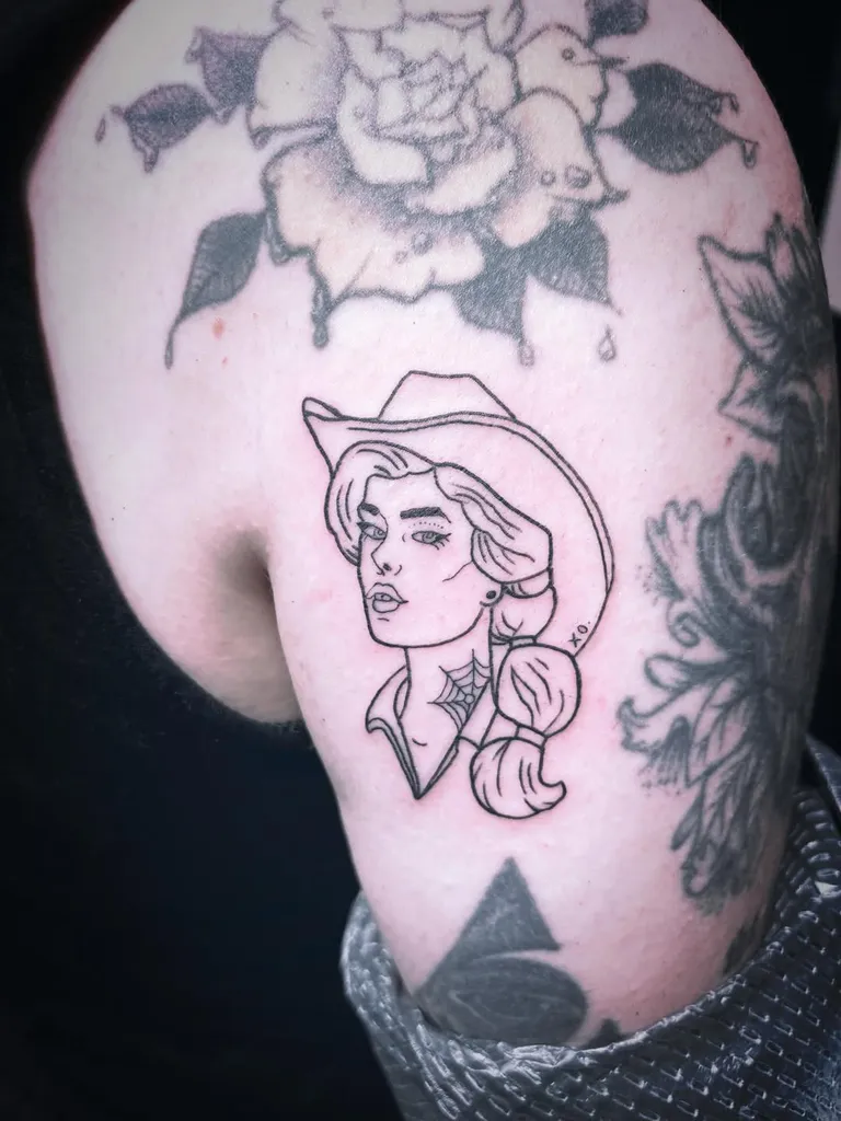 Cowgirl portrait tattoo on the upper arm by Melissa at Golden Child Tattoo in Escondido