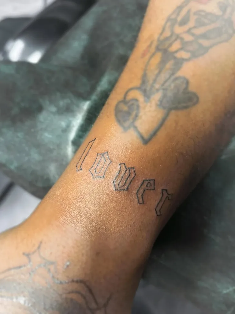 Lover lettering tattoo in blackletter script on the forearm by Melissa at Golden Child Tattoo in Escondido