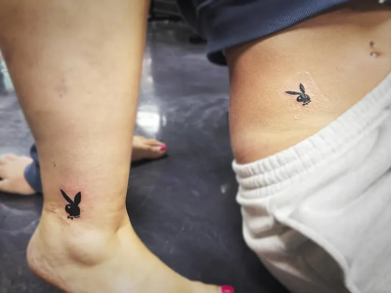 Matching small bunny logo tattoos on an ankle and a hip by Melissa at Golden Child Tattoo in Escondido