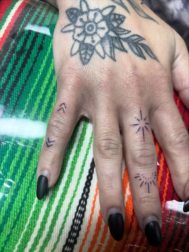 Small sparkle and line tattoos on the fingers by Melissa at Golden Child Tattoo in Escondido