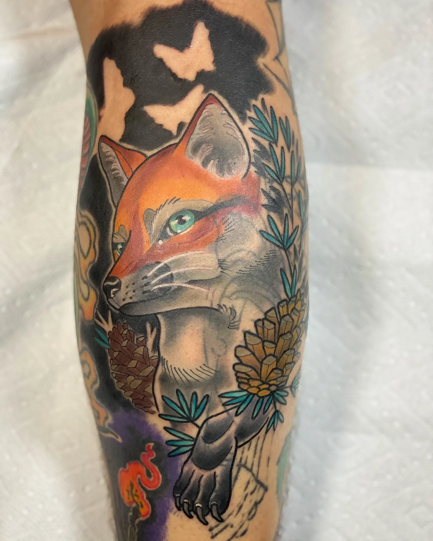 Neo-traditional fox tattoo with pine cones and branches by Mathias Moretti at Golden Child Tattoo in Escondido