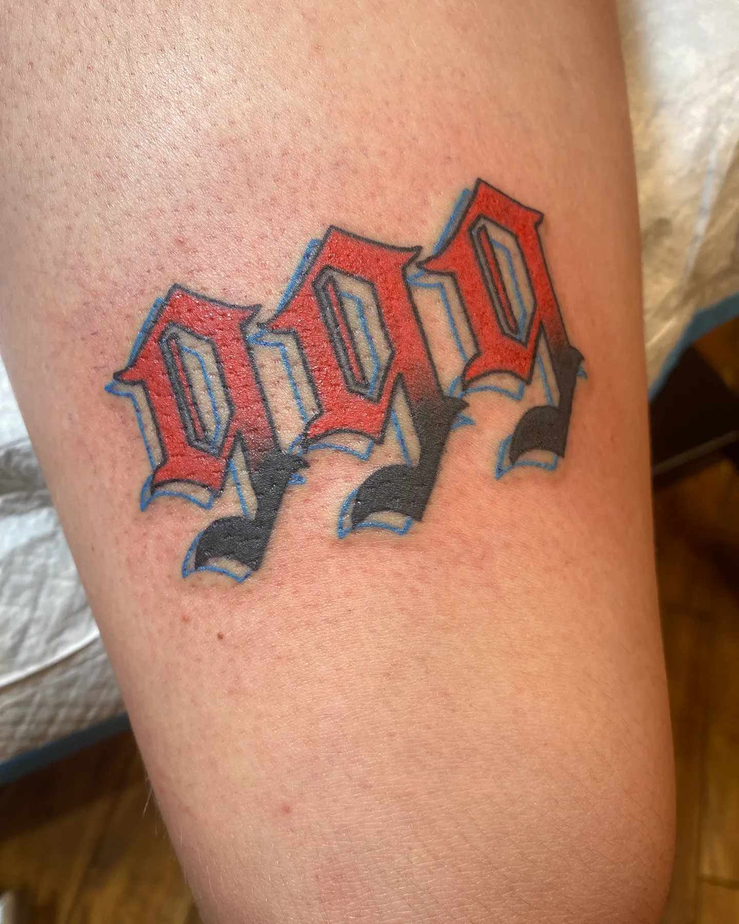 Bold red and black lettering tattoo by Mathias Moretti at Golden Child Tattoo in Escondido
