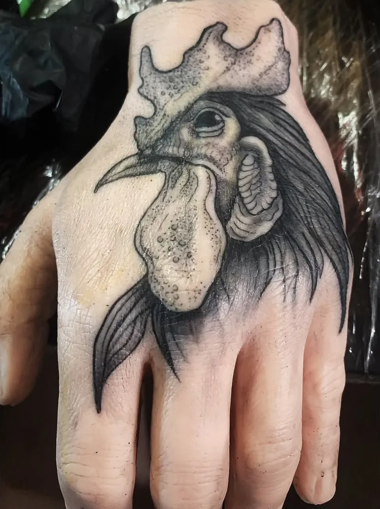 Black and grey rooster tattoo on the back of a hand by Melissa at Golden Child Tattoo in Escondido